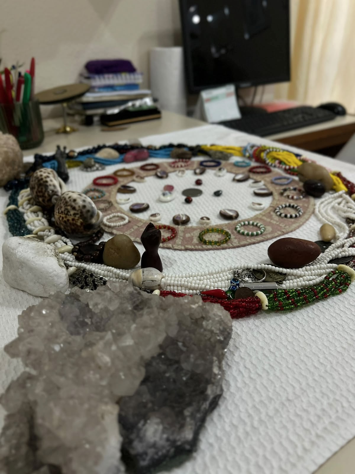 Contas, pedras e objetos organizados sobre uma mesa.
