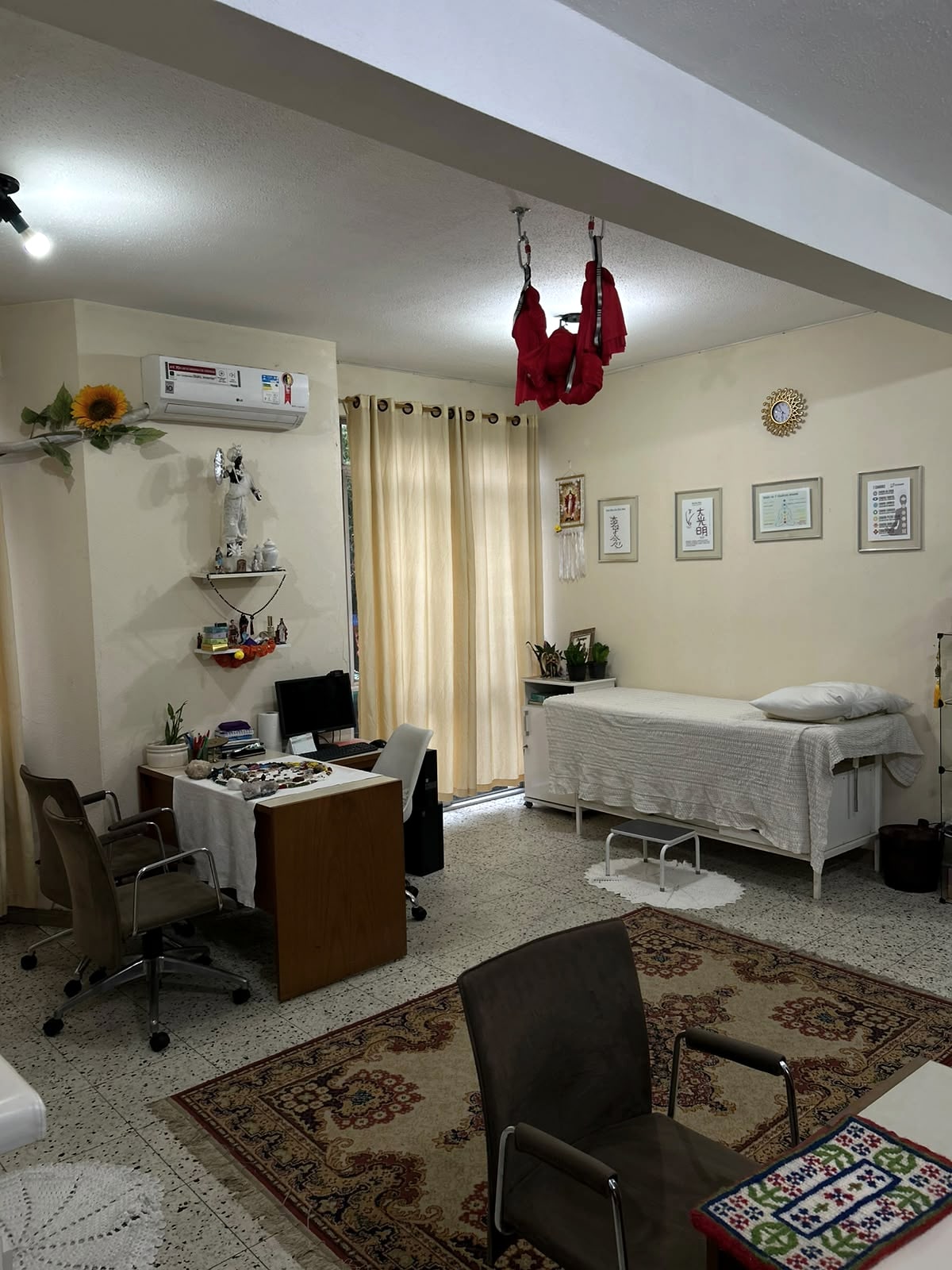 Sala de atendimento com maca e área de conversa.